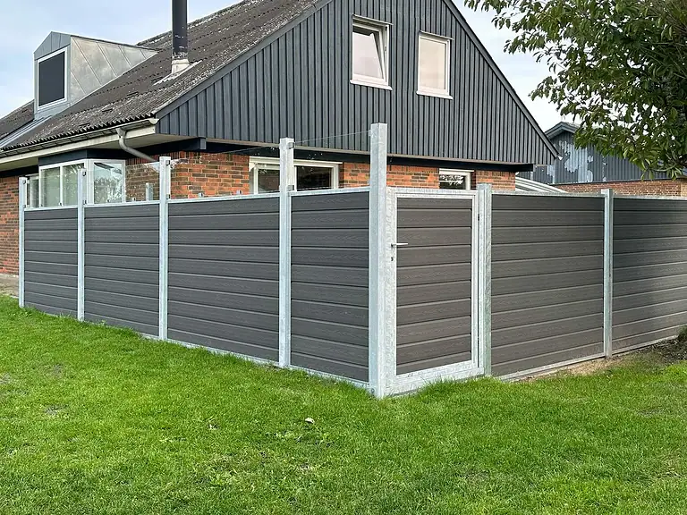 Komposithegn med bundplader på græsplænen ved huset