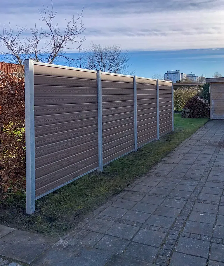 Brunt komposithegn langs en flisegang