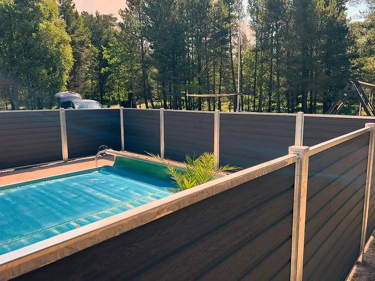 Komposithegn med galvaniserede stolper rundt om poolen