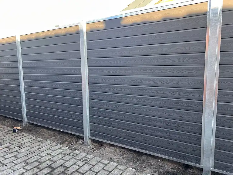 Komposithegn med varmgalvaniserede stolper langs en belægning